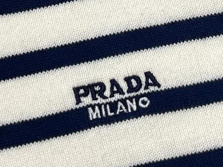 Вышитый логотип Prada Milano на груди крупным планом