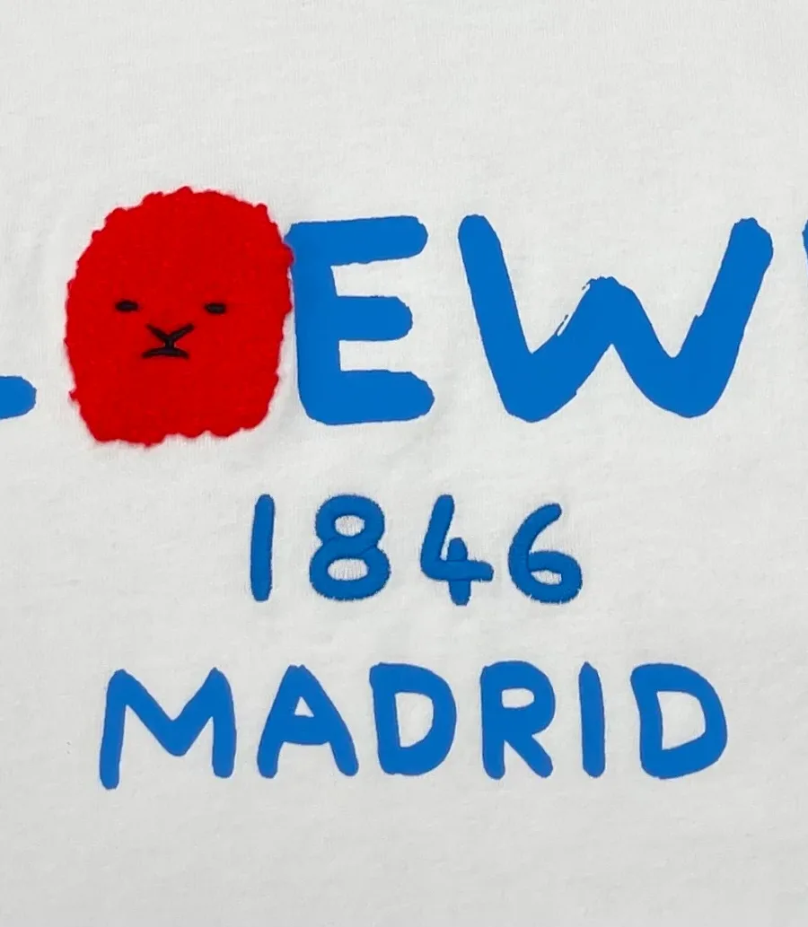 Крупный план принта с синей надписью LOEWE 1846 MADRID и красным рисунком