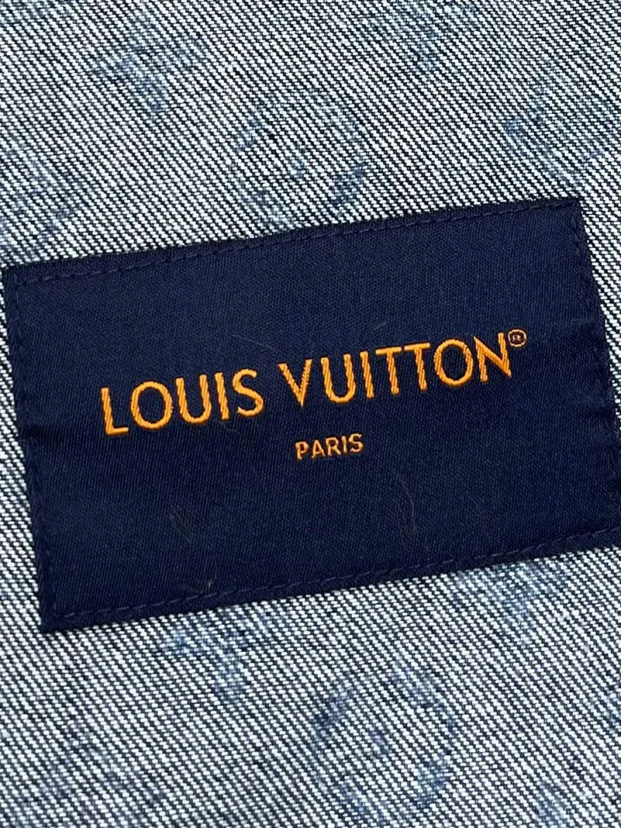Фирменная бирка Louis Vuitton Paris на фоне денима