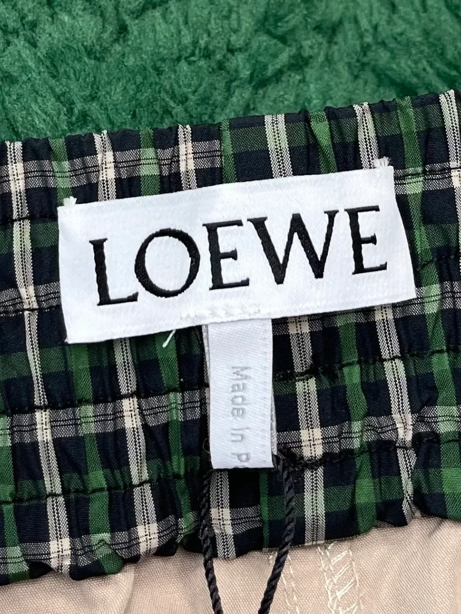 Текстильная бирка бренда Loewe на внутренней стороне клетчатого пояса