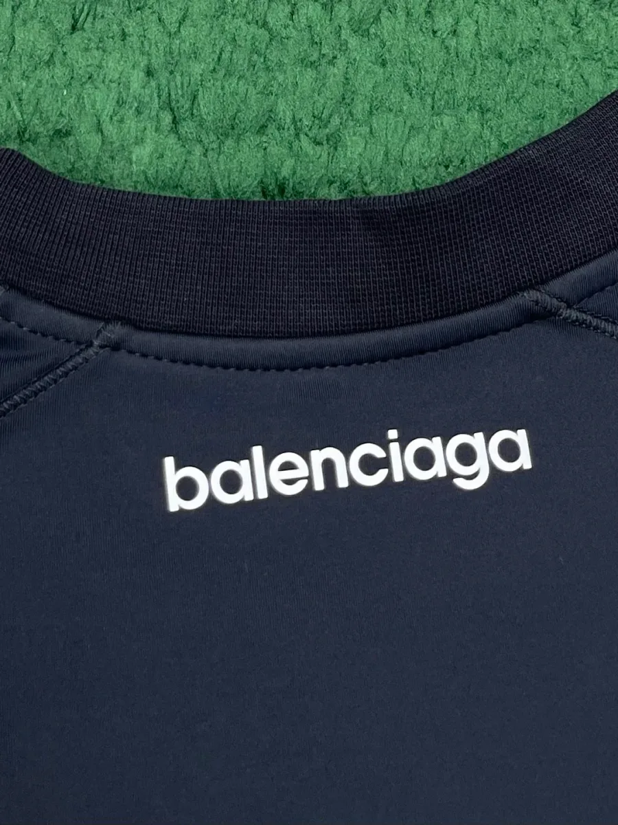 Круглый вырез тёмно-синей футболки со спины с белой надписью Balenciaga