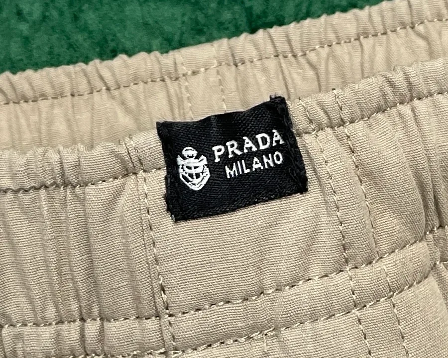 Текстильная нашивка с логотипом Prada Milano на поясе брюк