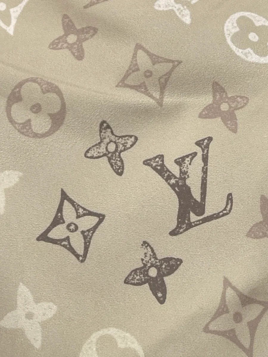Крупный план фактуры ткани с фирменным узором Monogram