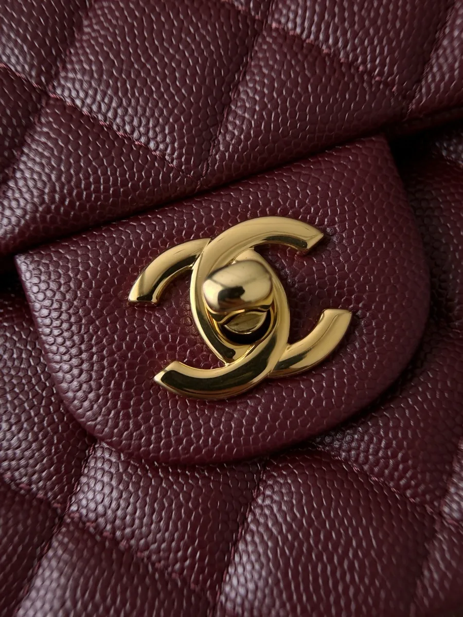 Золотистый поворотный замок CC на бордовой зернистой коже сумки Chanel