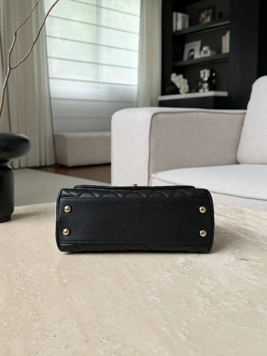 Дно чёрной сумки Chanel Coco Handle с четырьмя защитными металлическими ножками