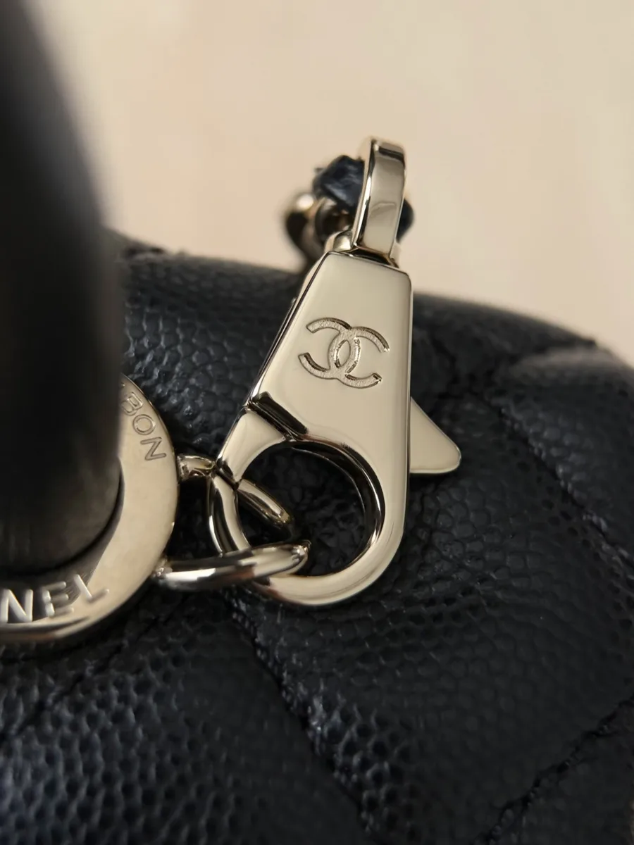 Крупный план крепления плечевого ремня-цепочки к ручке сумки Chanel