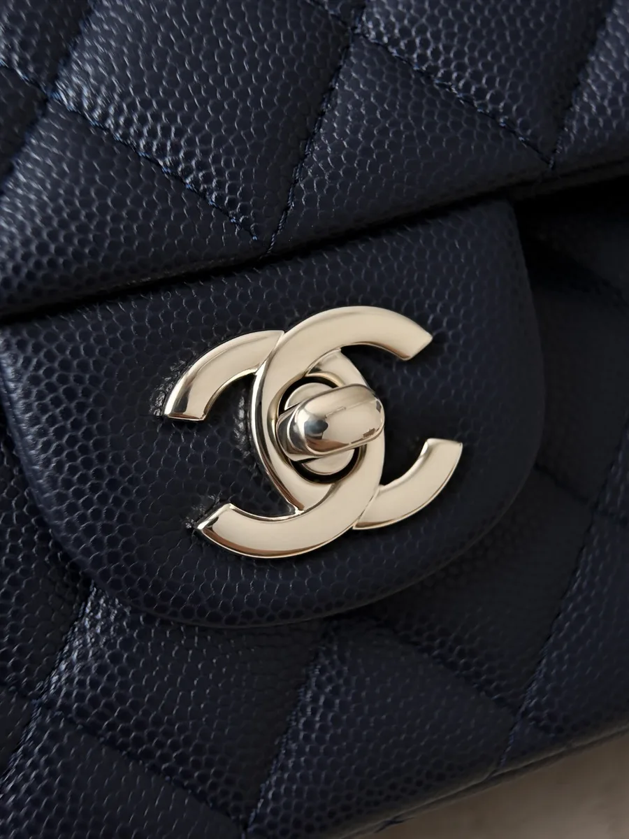 Золотистый поворотный замок CC на темно-синей сумке Chanel Classic Flap