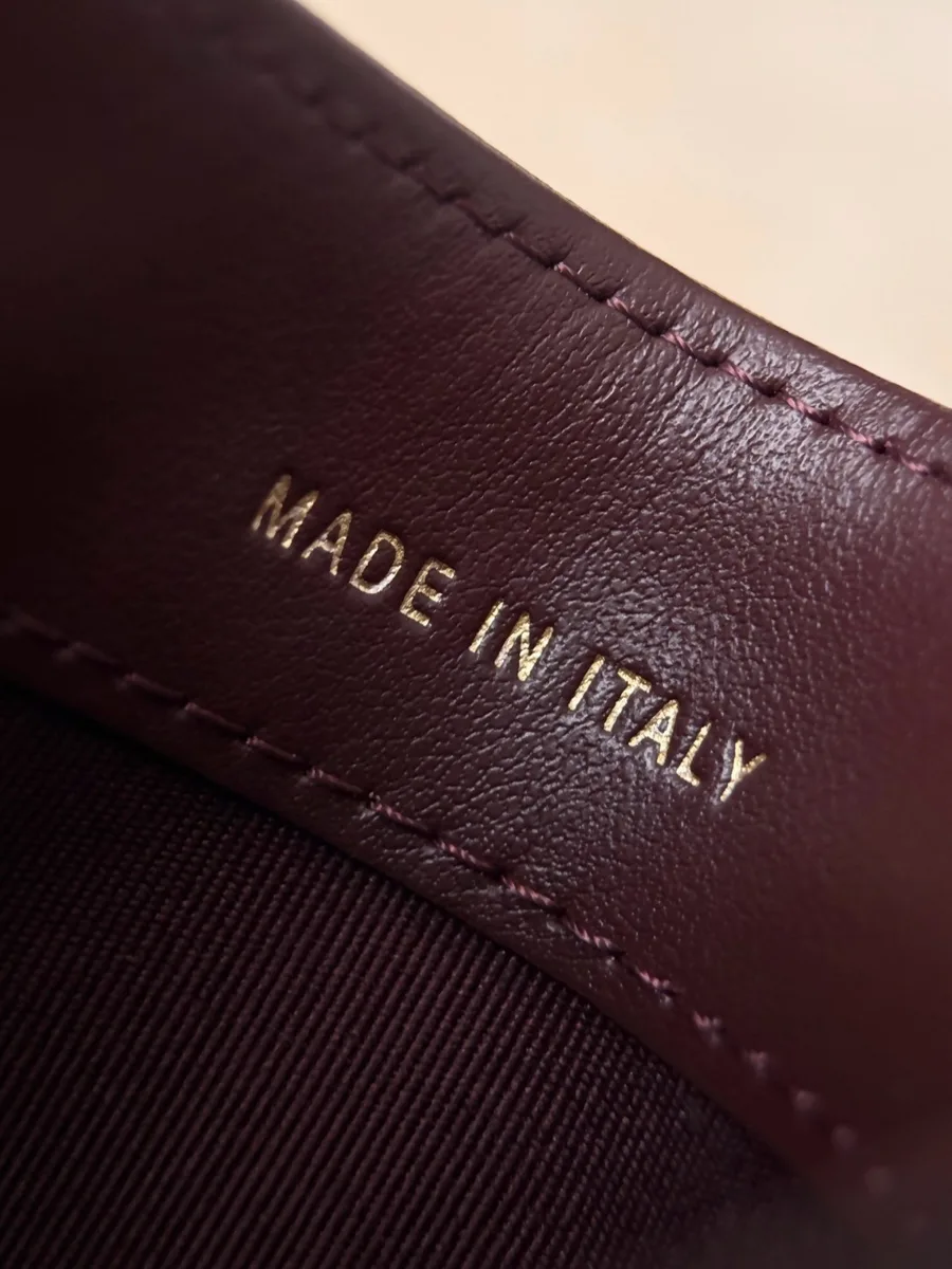 Золотистое тиснение Made in Italy на бордовой кожаной подкладке картхолдера
