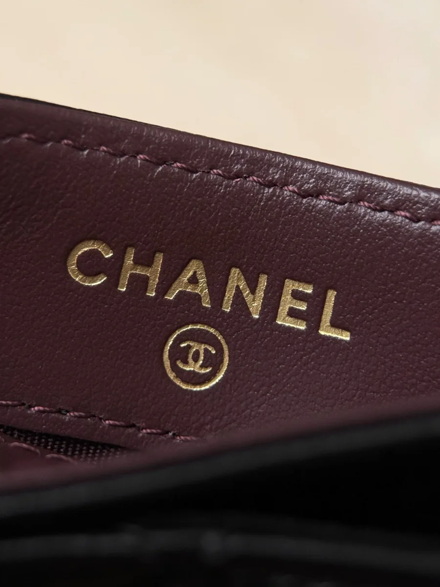 Золотистый логотип Chanel на внутренней бордовой отделке аксессуара