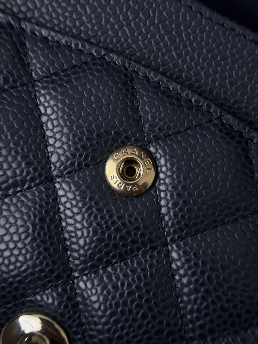 Крупный план золотистой кнопки-заклепки с гравировкой Chanel