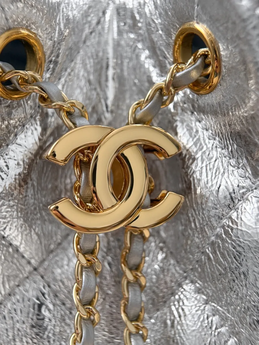 Золотистая застежка-кулиска в виде логотипа CC на серебристой сумке Chanel