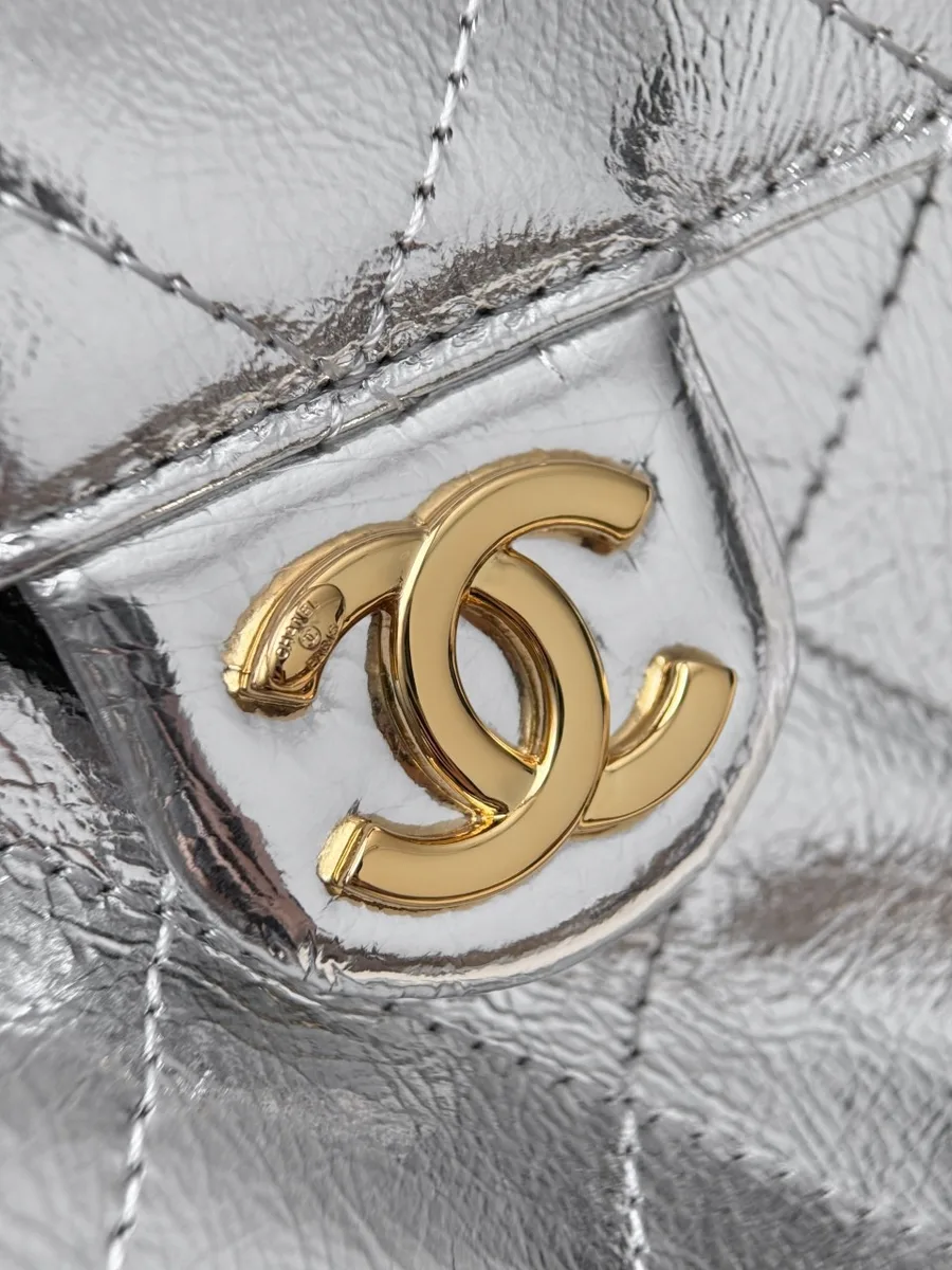 Золотистый логотип CC на клапане бокового кармана серебристой сумки Chanel