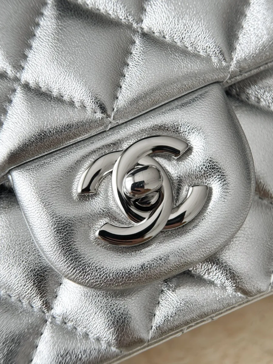 Крупный план серебристого поворотного замка CC на клапане сумки Chanel