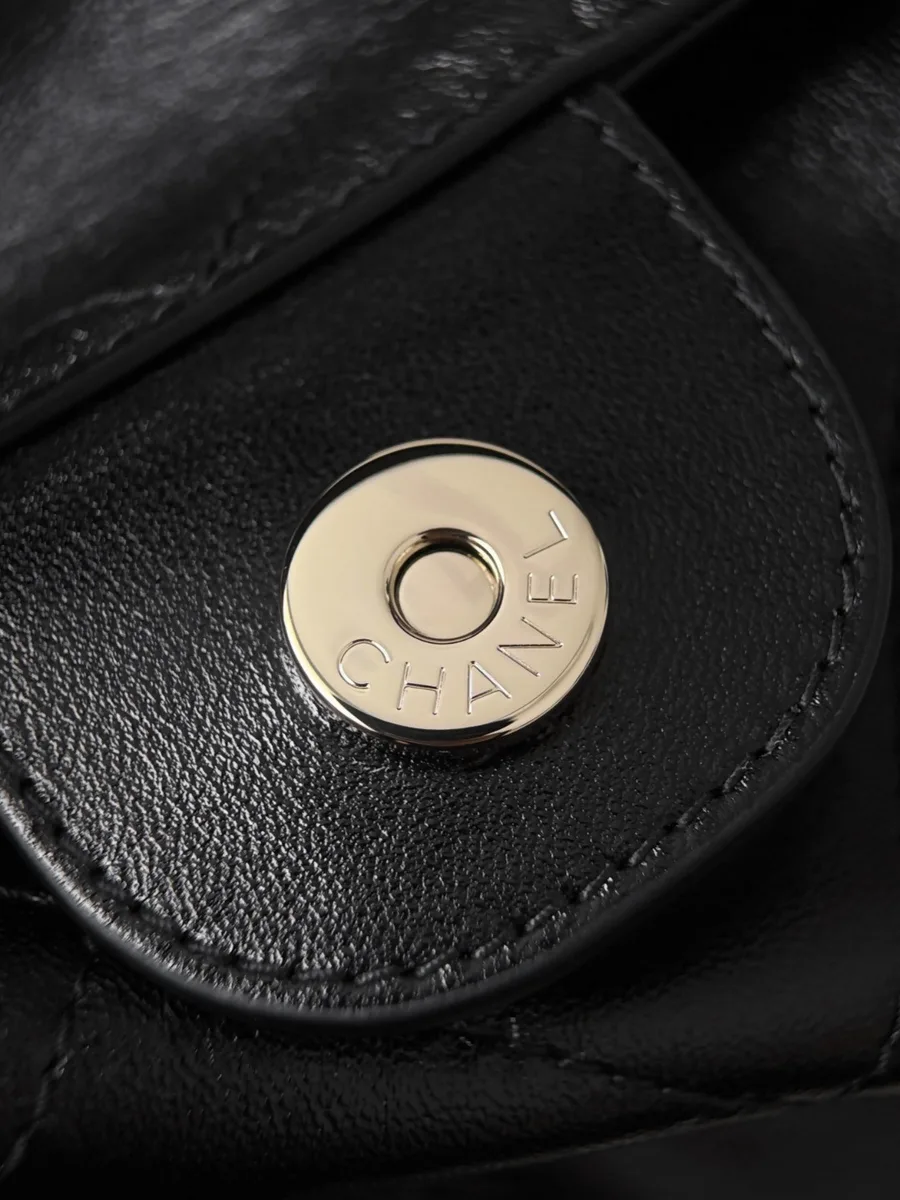 Крупный план магнитной кнопки-застёжки с гравировкой Chanel