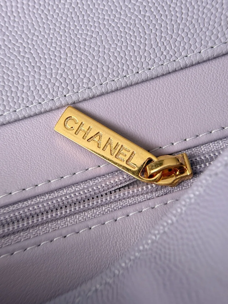 Крупный план золотистой молнии с надписью Chanel внутри сумки
