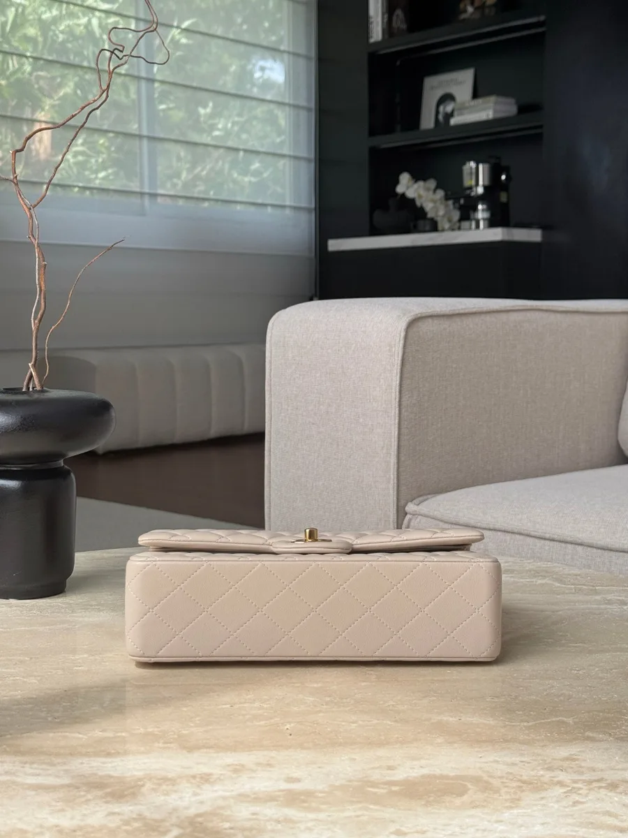 Нижняя часть бежевой кожаной сумки Chanel Classic Flap на ровной поверхности