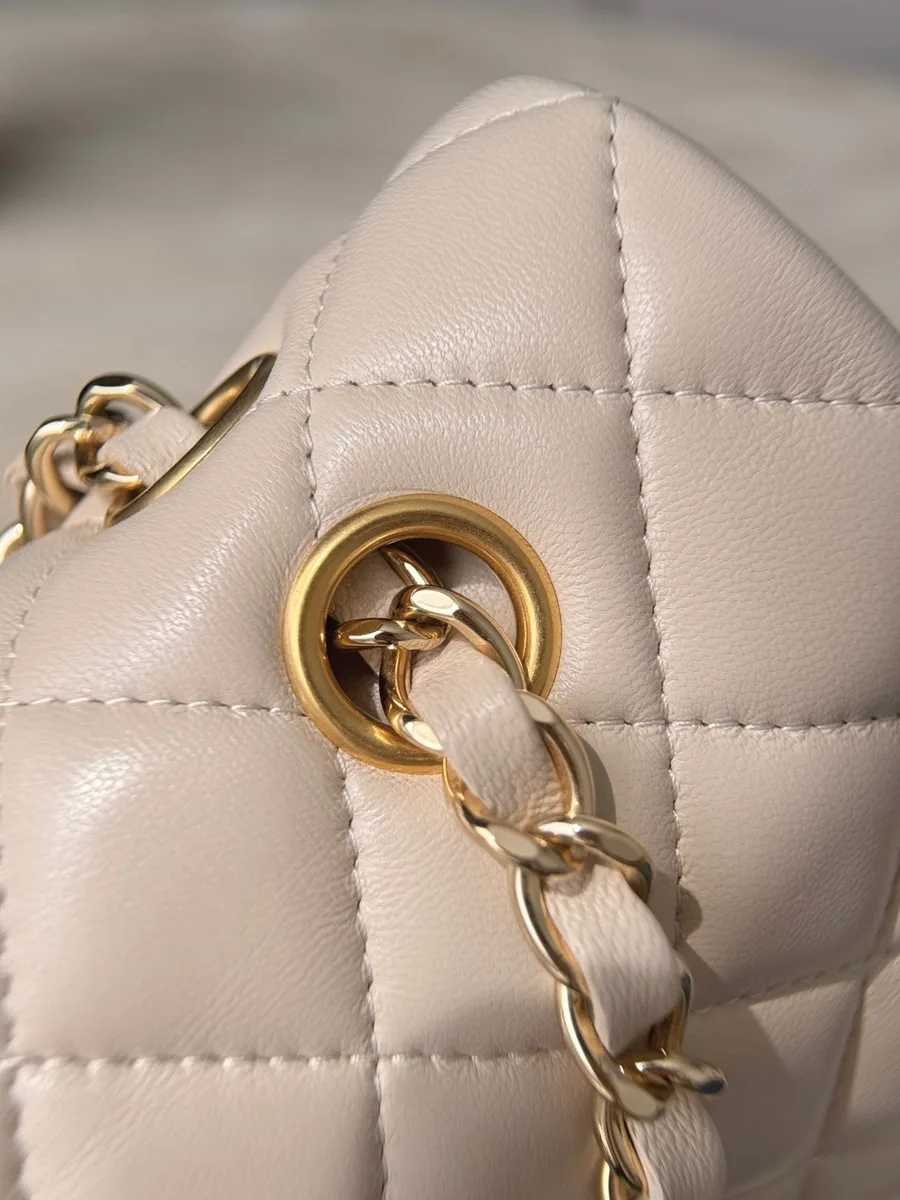 Золотистый металлический люверс на бежевой кожаной сумке Chanel