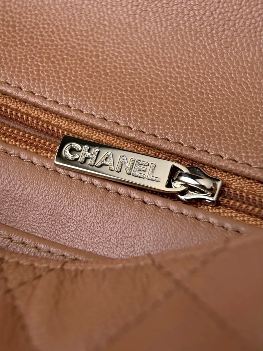 Крупный план металлического пуллера молнии с гравировкой Chanel внутри сумки
