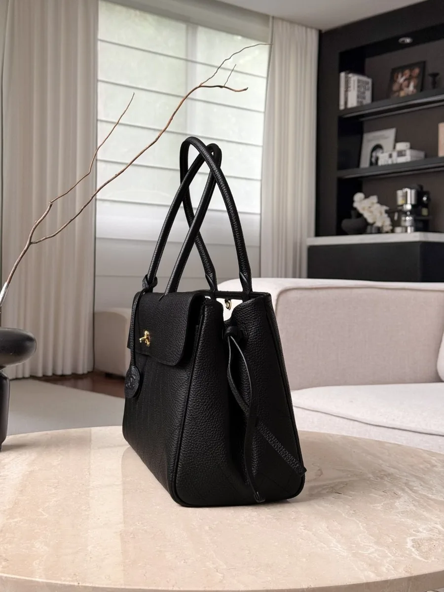 Чёрная сумка Chanel Baguette Bag, вид сбоку, демонстрирующий форму и боковые завязки