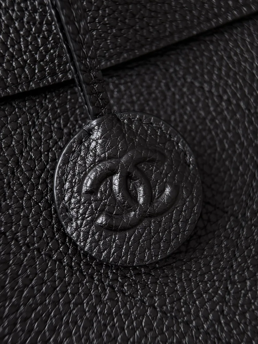 Кожаный круглый брелок с тиснением CC на сумке Chanel