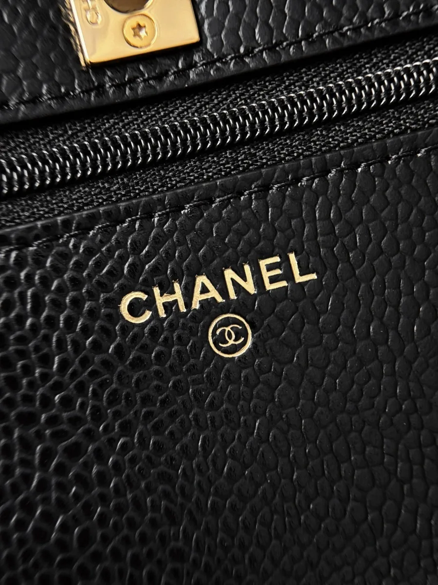 Золотистое тиснение логотипа Chanel на внутренней кожаной части сумки