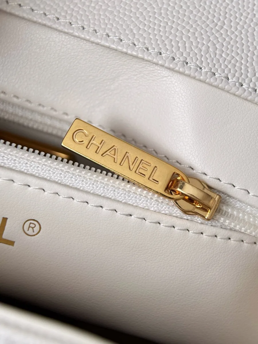 Крупный план золотистой молнии с гравировкой Chanel внутри сумки