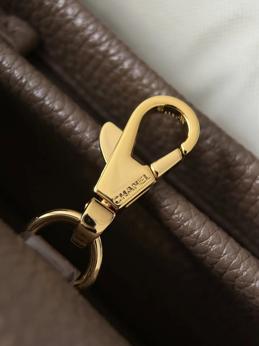 Крупный план золотистого металлического карабина с гравировкой Chanel