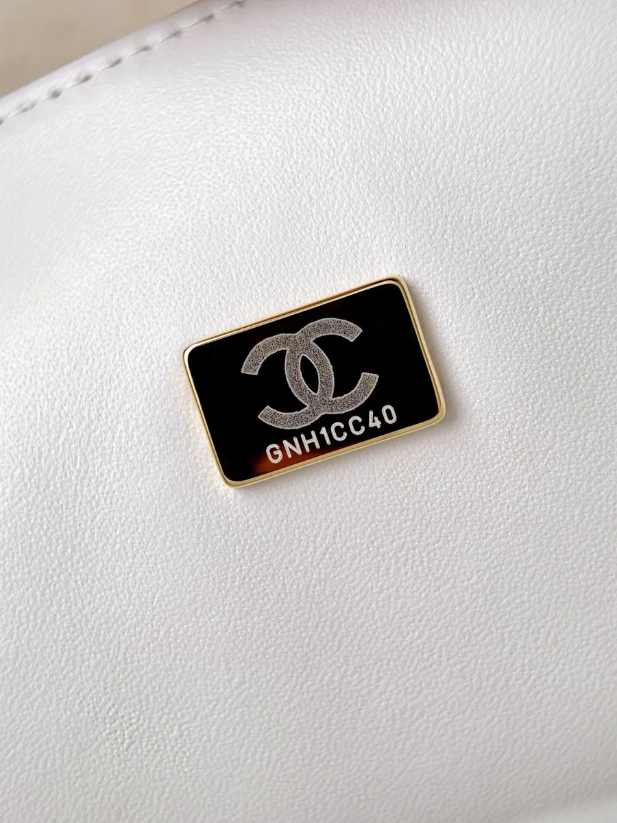 Металлическая пластина с серийным номером внутри белой сумки Chanel