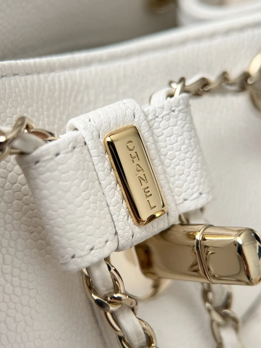 Деталь кожаного шнурка с золотистым металлическим фиксатором с гравировкой Chanel