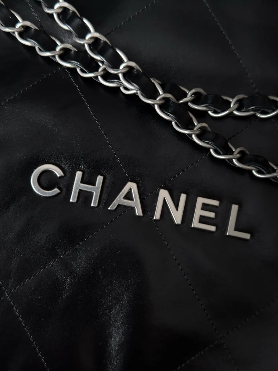 Крупный план серебристой надписи Chanel на передней части сумки