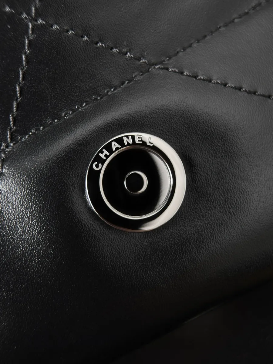 Крупный план металлической кнопки-застёжки с гравировкой Chanel