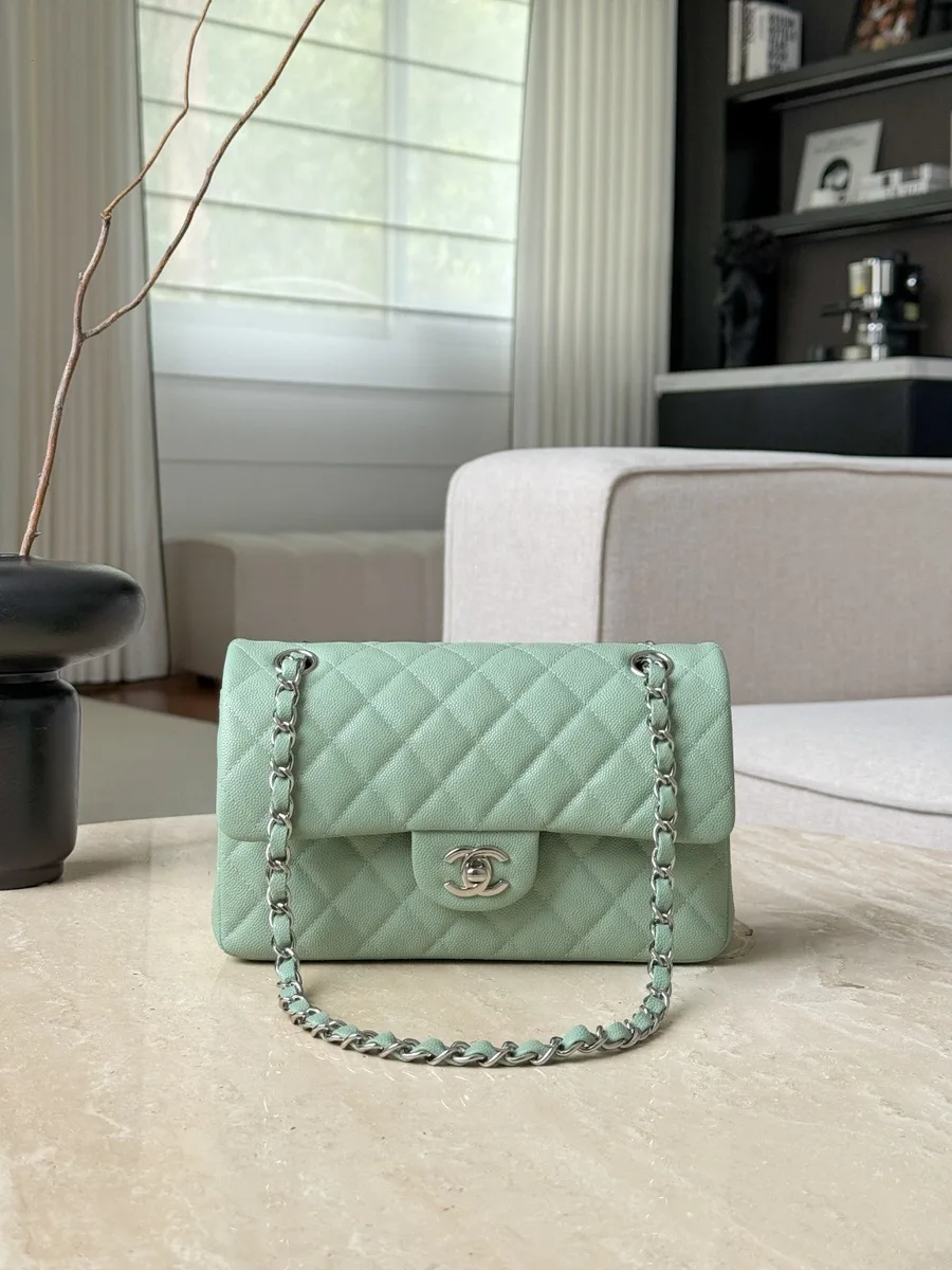 Светло-зелёная сумка Chanel Classic Flap на столе, вид спереди