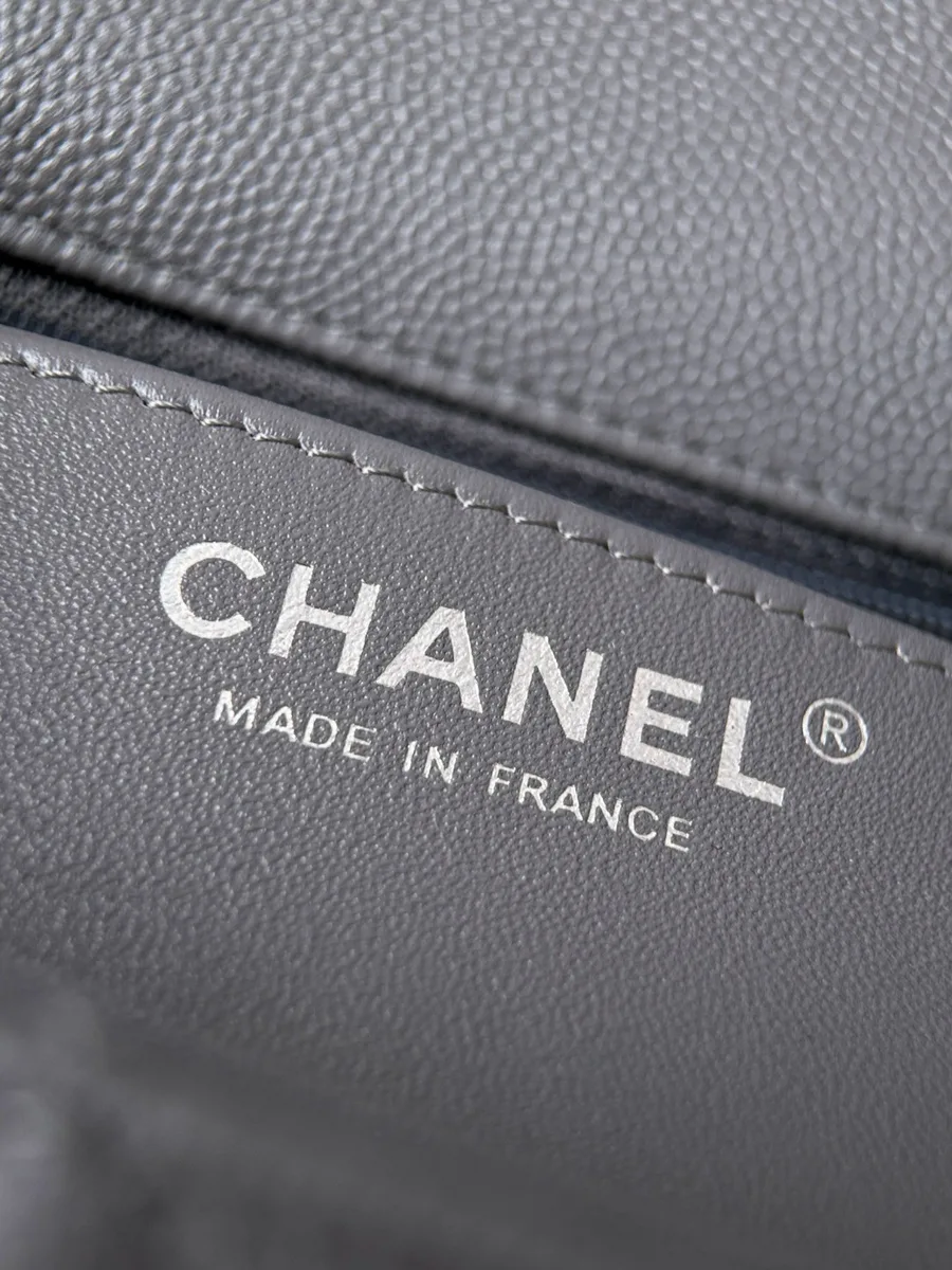 Крупный план серебристого тиснения Chanel Made in France внутри сумки.