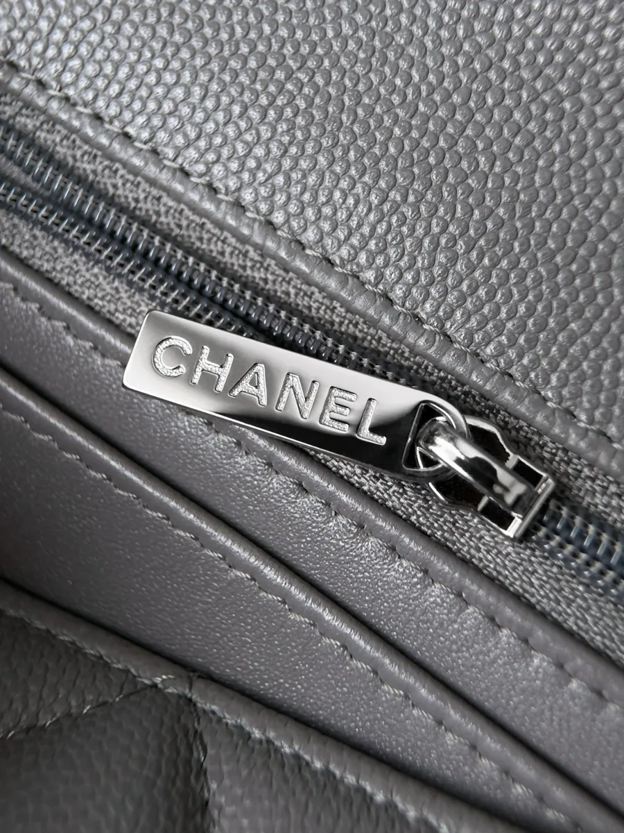 Крупный план молнии с брендированным бегунком Chanel во внутреннем кармане.