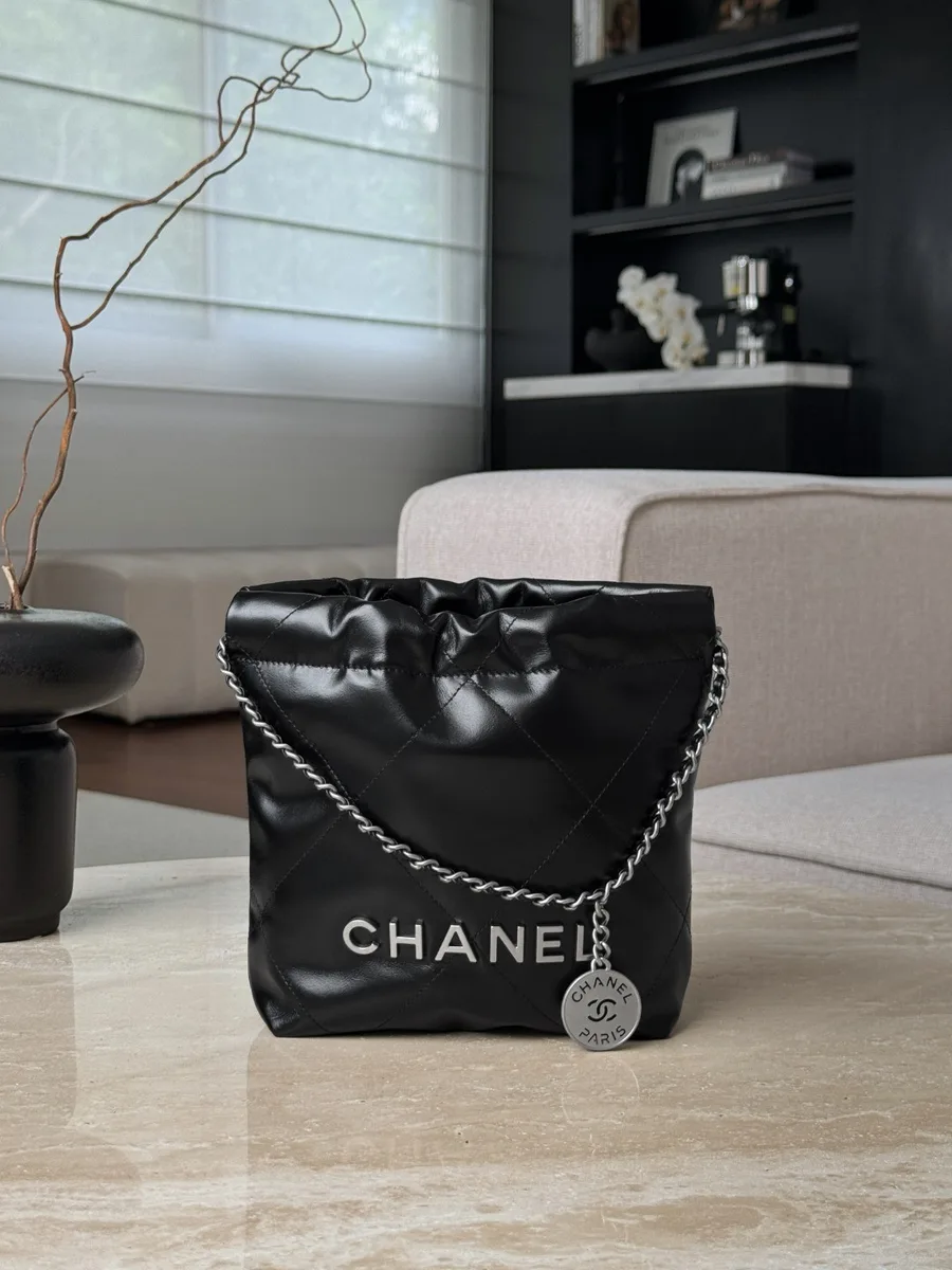 Черная сумка-мешок Chanel 22 Mini на столе, вид спереди