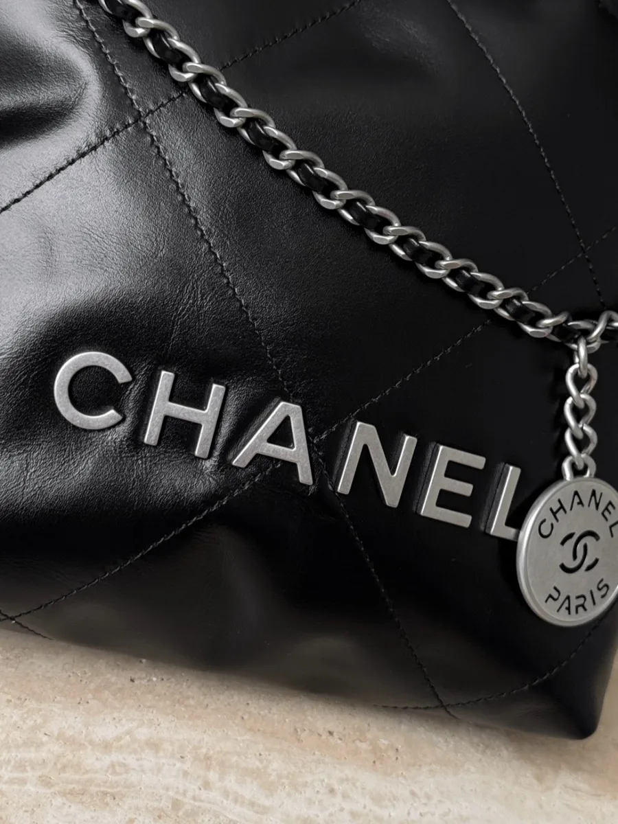 Серебристые металлические буквы Chanel на лицевой стороне сумки