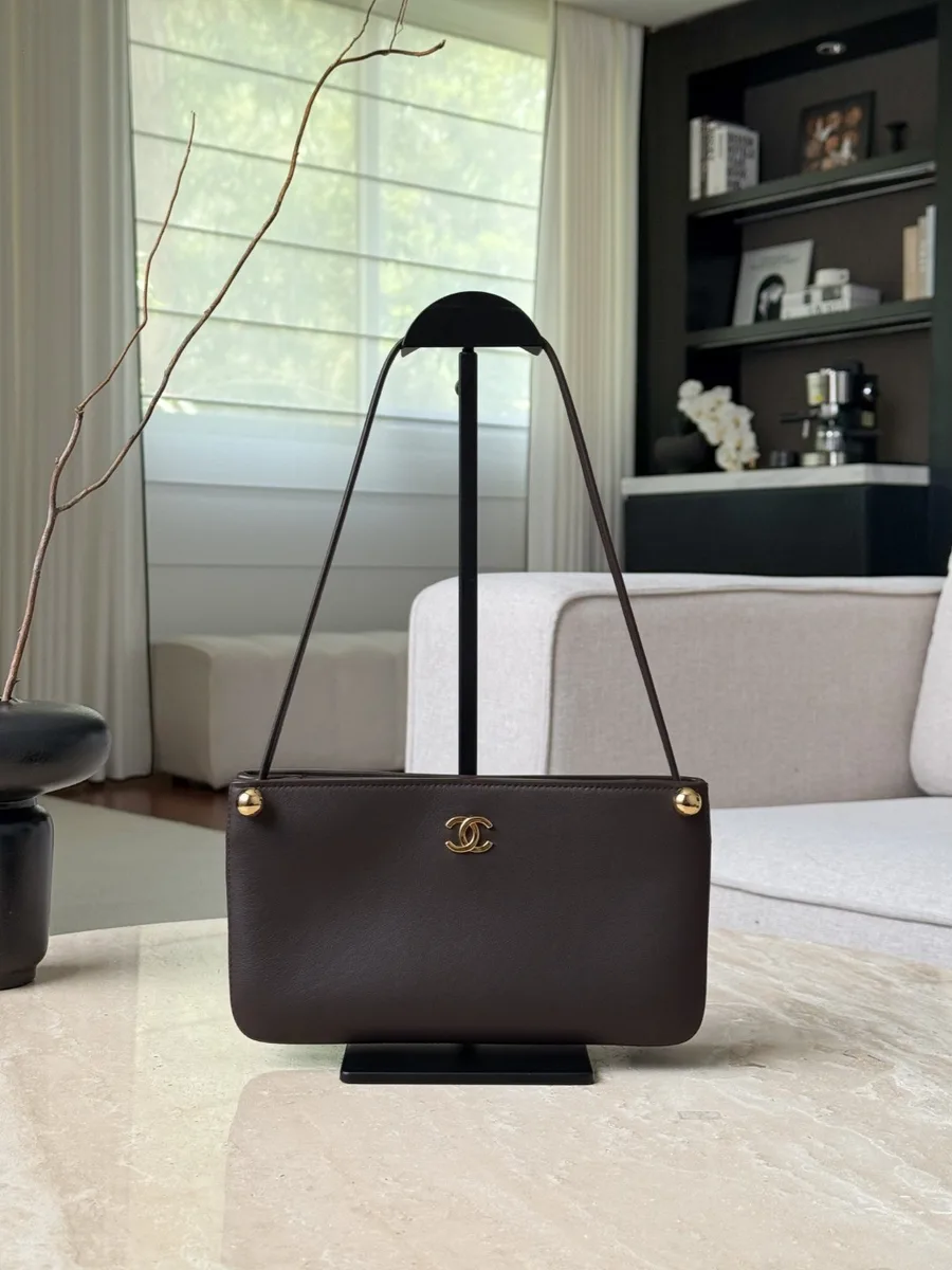 Коричневая сумка на плечо Chanel, вид спереди на подставке