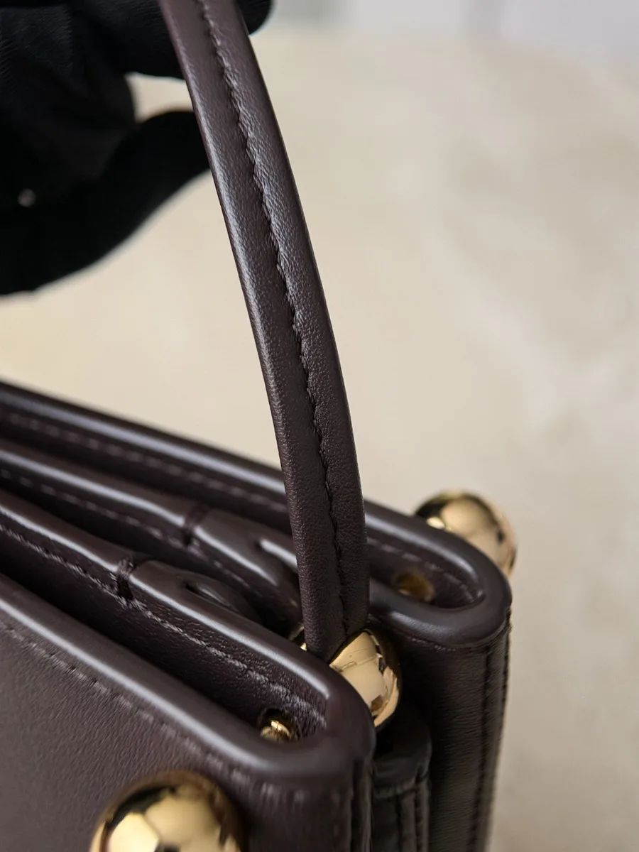 Деталь крепления тонкого кожаного ремешка коричневой сумки Chanel