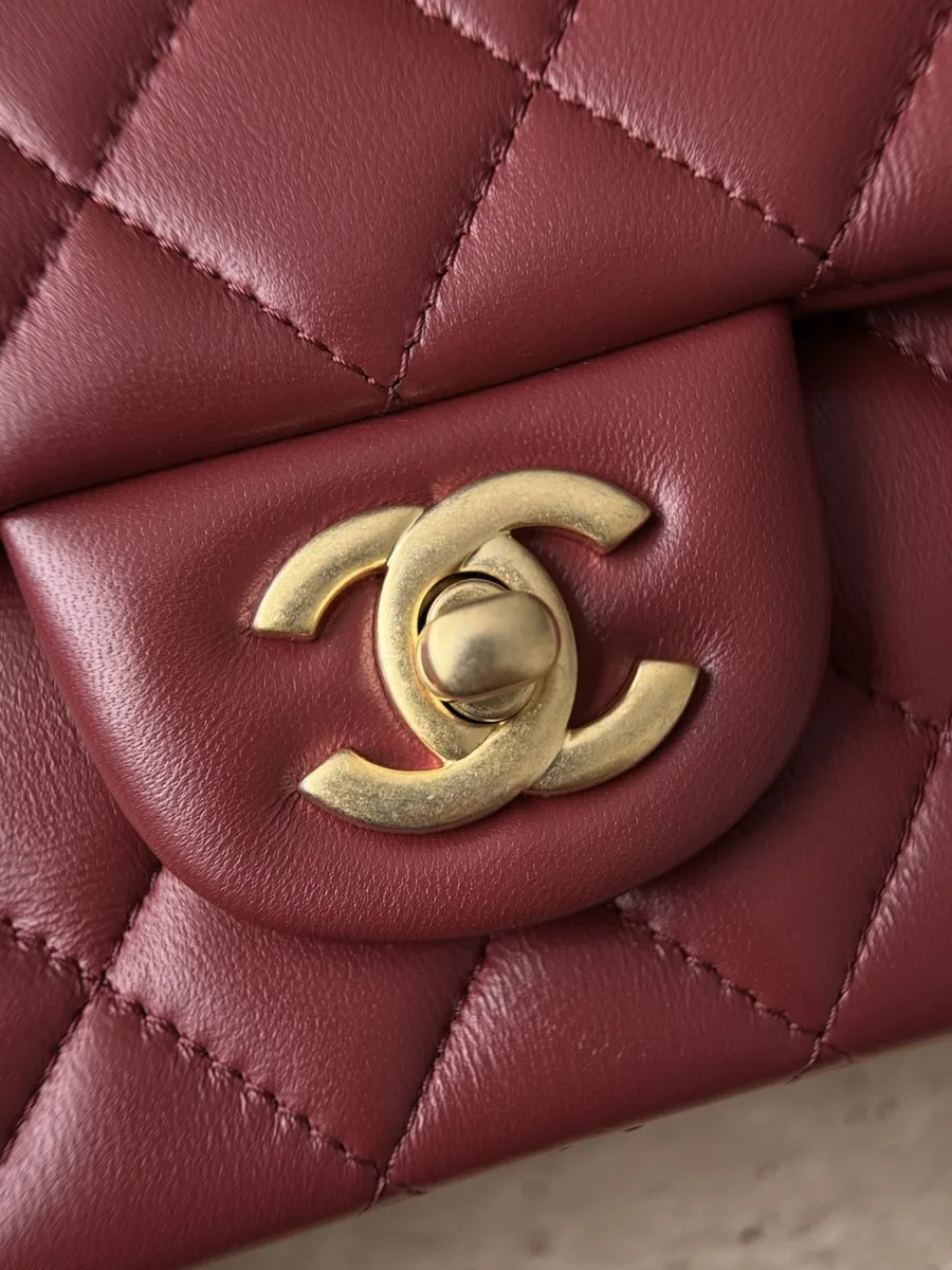 Золотистый поворотный замок CC на бордовой сумке Chanel