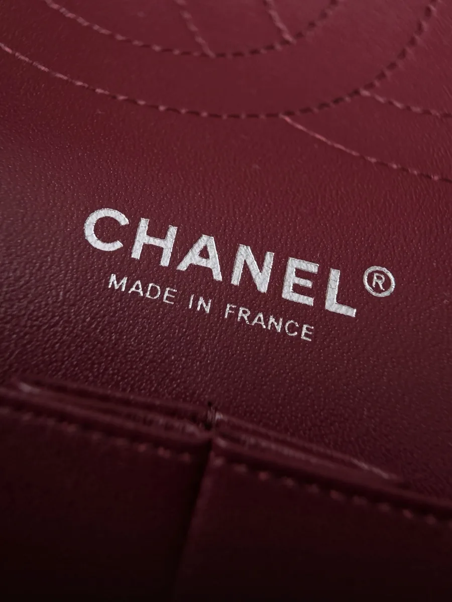 Серебристый логотип Chanel Made in France на внутренней стороне бордовой сумки