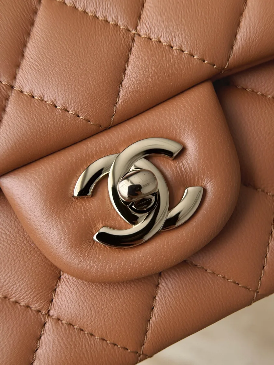 Крупный план поворотного замка CC из золотистого металла на клапане сумки Chanel