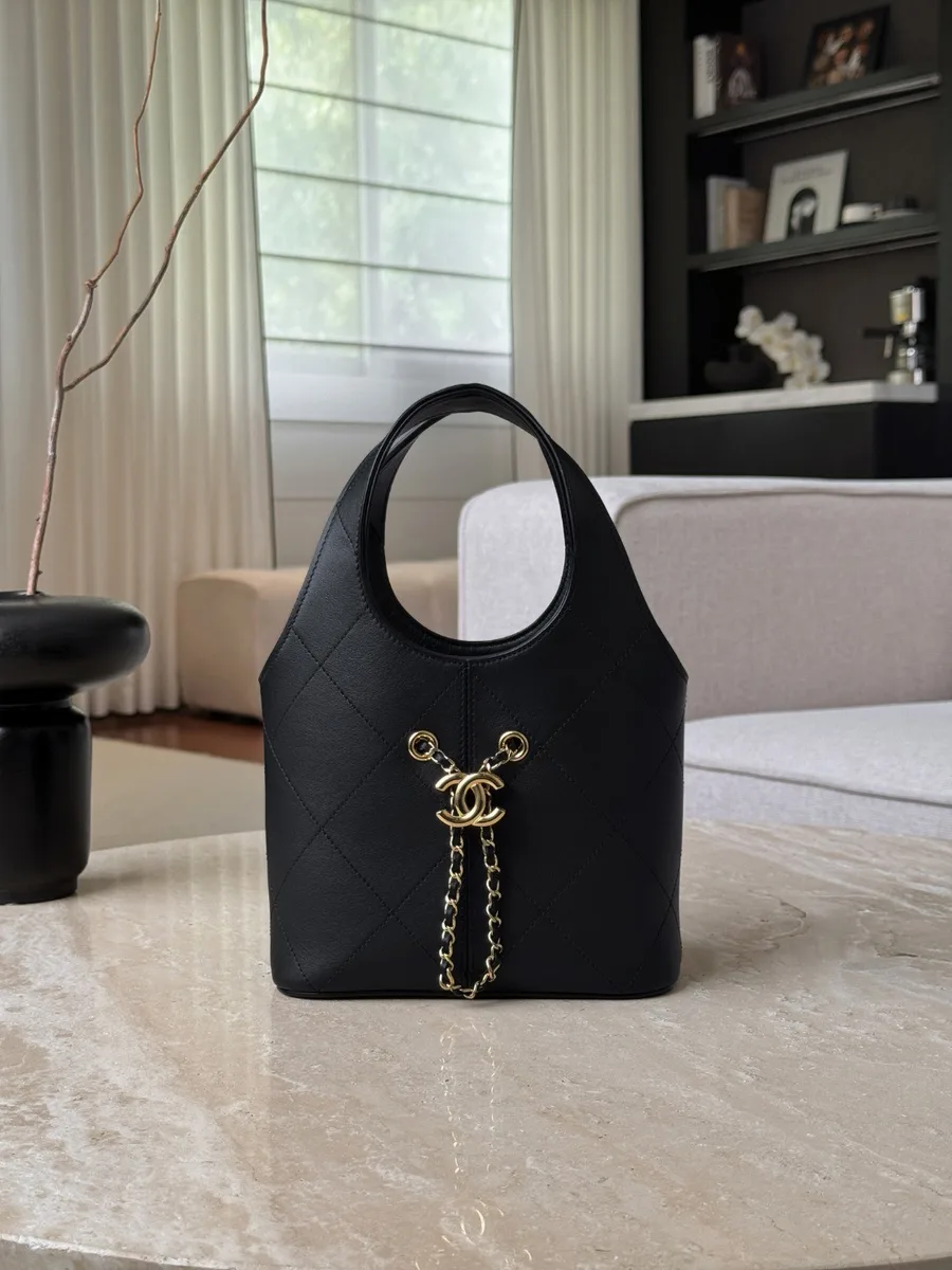 Чёрная кожаная сумка-ведро Chanel Hobo с золотистой подвеской CC на передней панели, вид спереди