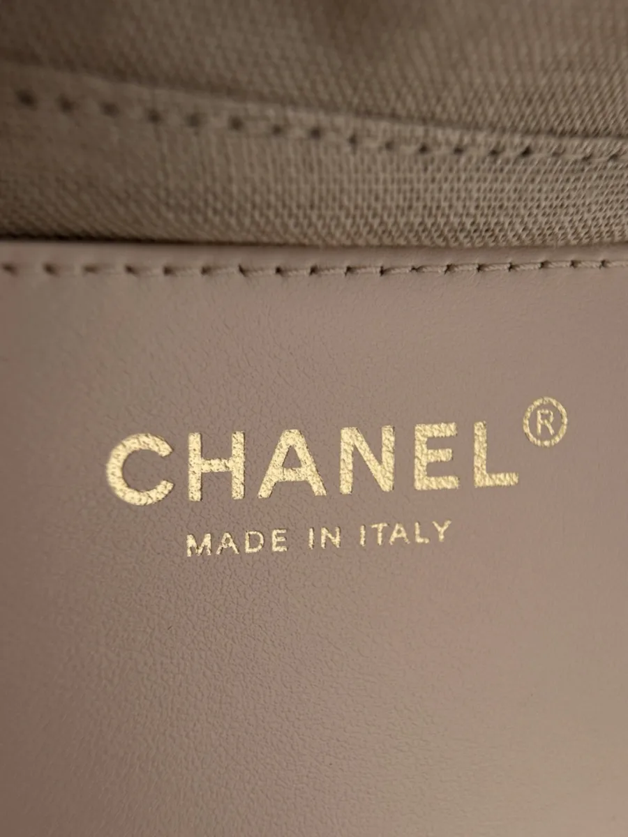 Золотистое тиснение Chanel Made in Italy на бежевой кожаной детали внутри сумки