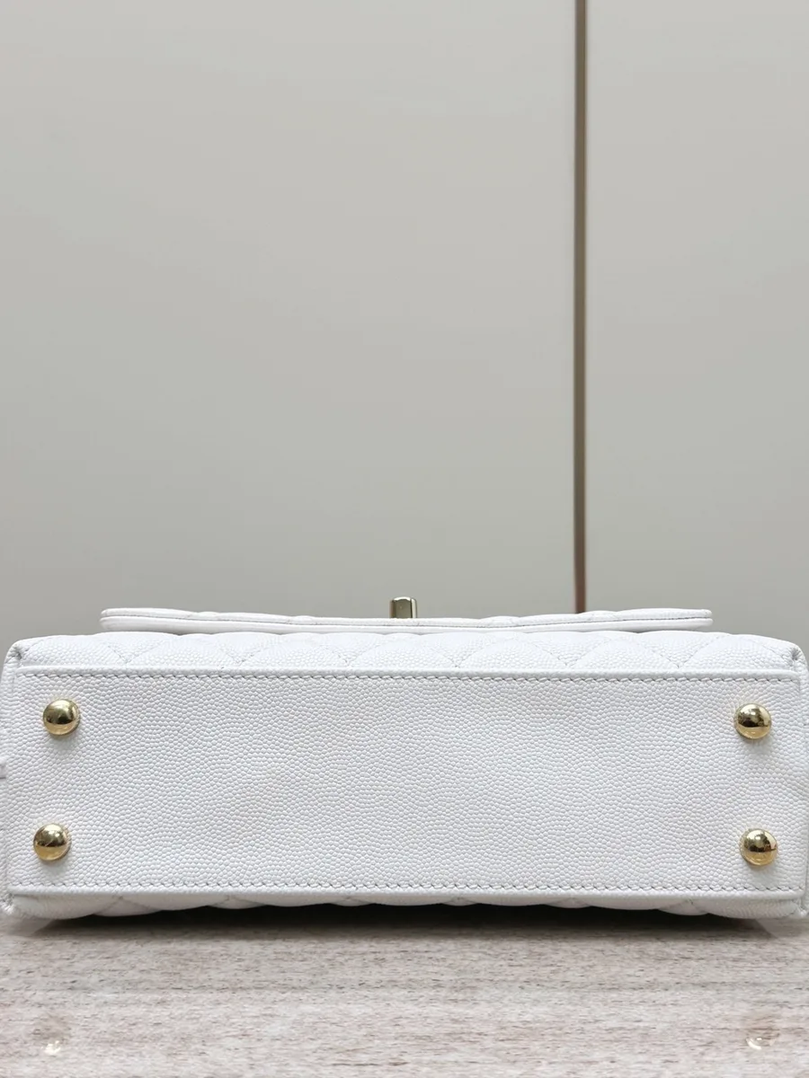 Сумка Chanel Coco Handle из белой зернистой кожи, вид снизу на металлические ножки