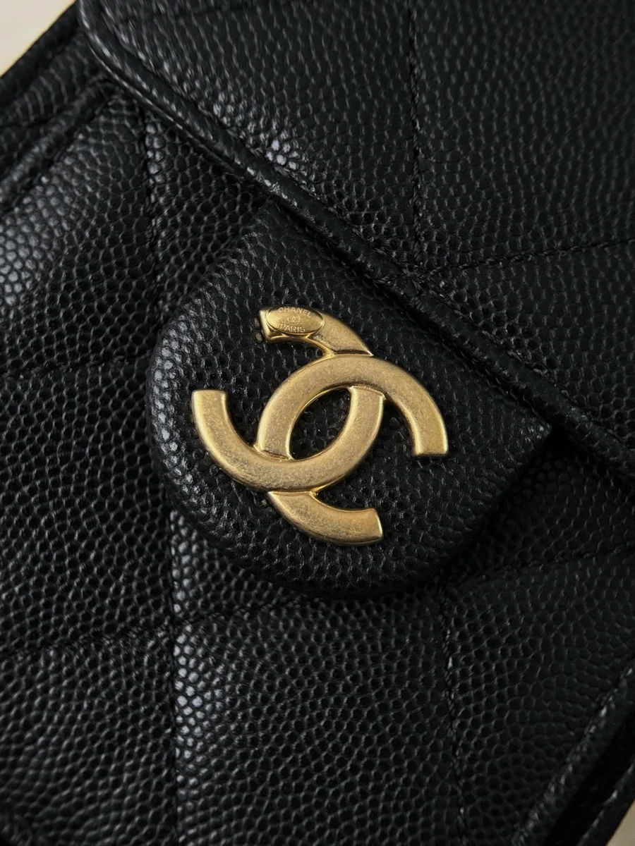 Золотистый логотип CC на клапане бокового кармана сумки Chanel.
