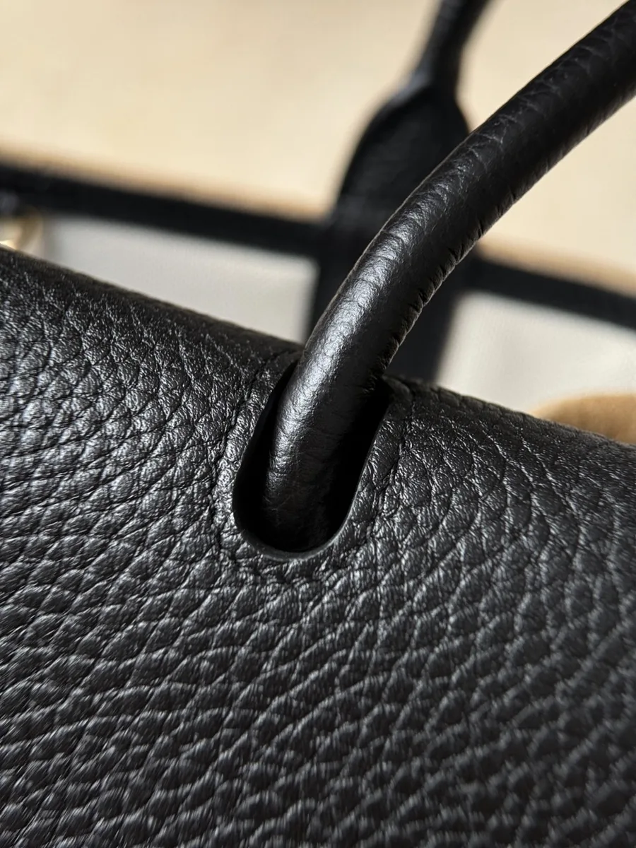 Сумка Chanel Baguette Bag из коричневой замши и чёрной кожи на светлом фоне
