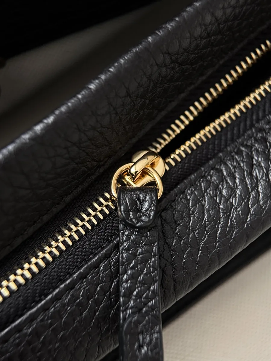 Крупный план золотистого карабина с гравировкой Chanel