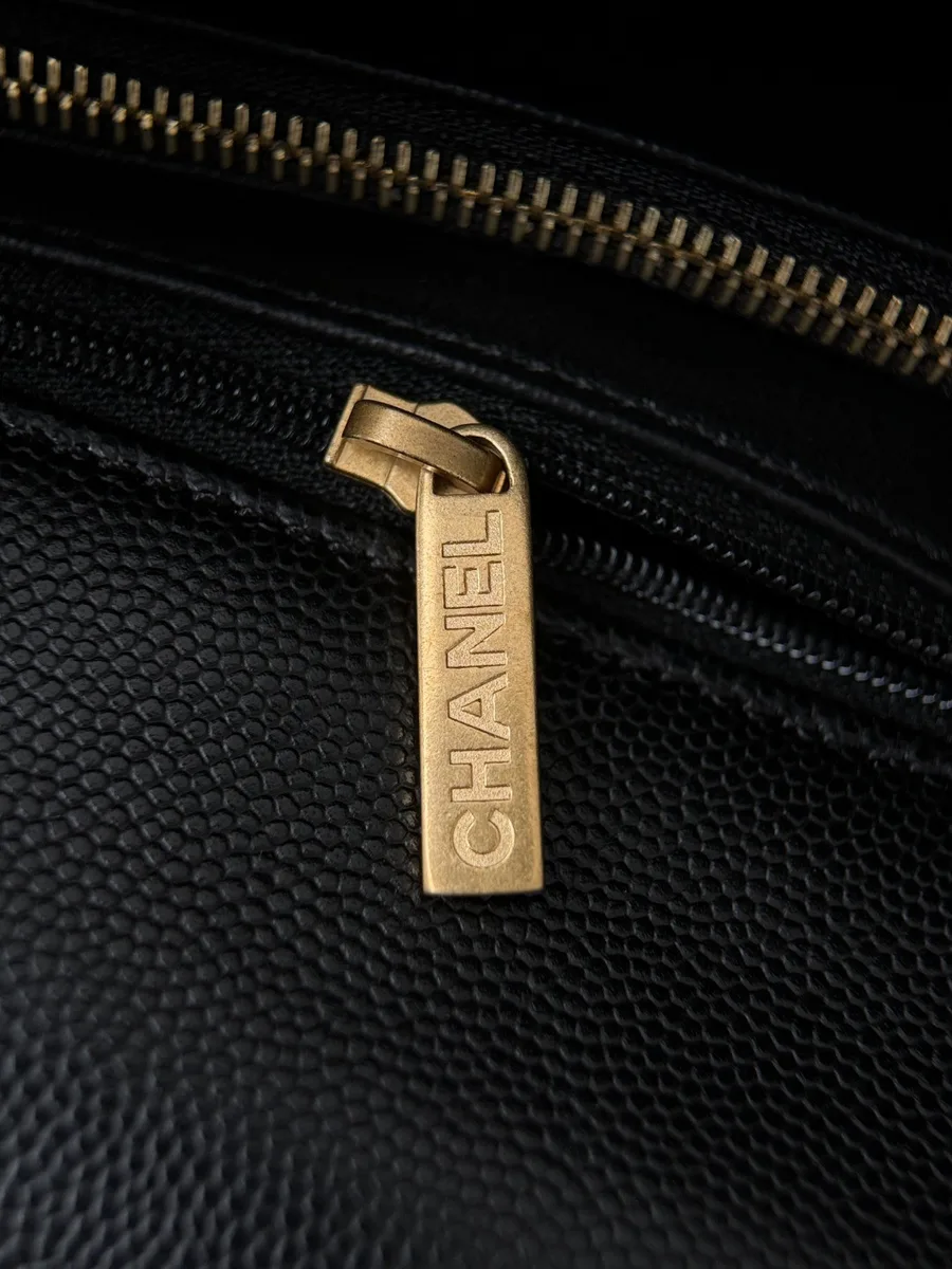 Золотистый пуллер молнии с гравировкой Chanel крупным планом