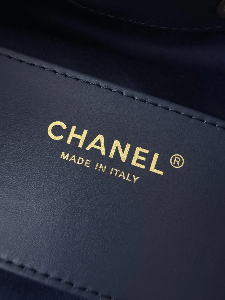 Крупный план золотистого тиснения Chanel Made in Italy внутри сумки