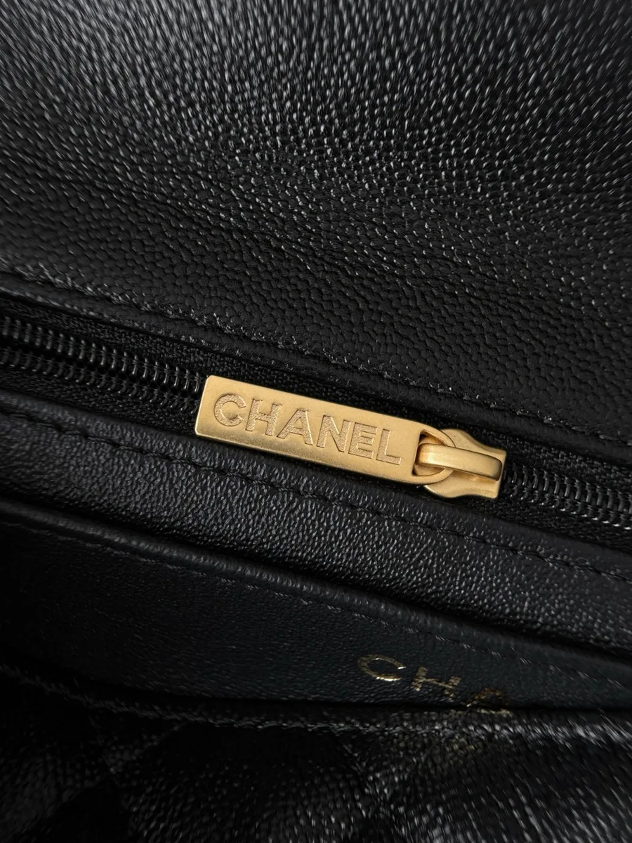 Золотистый пуллер молнии с гравировкой Chanel крупным планом